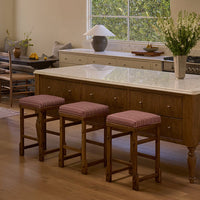 A bathroom with a red marble encased bathtub and the margo step stool next to it. 