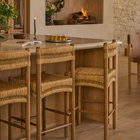 A light dining room with an oval oak dining table and Suma dining chairs in honey oak and rush. 