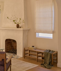 A desert style bedroom in late afternoon with a natural colored bench at the foot of the bed. 