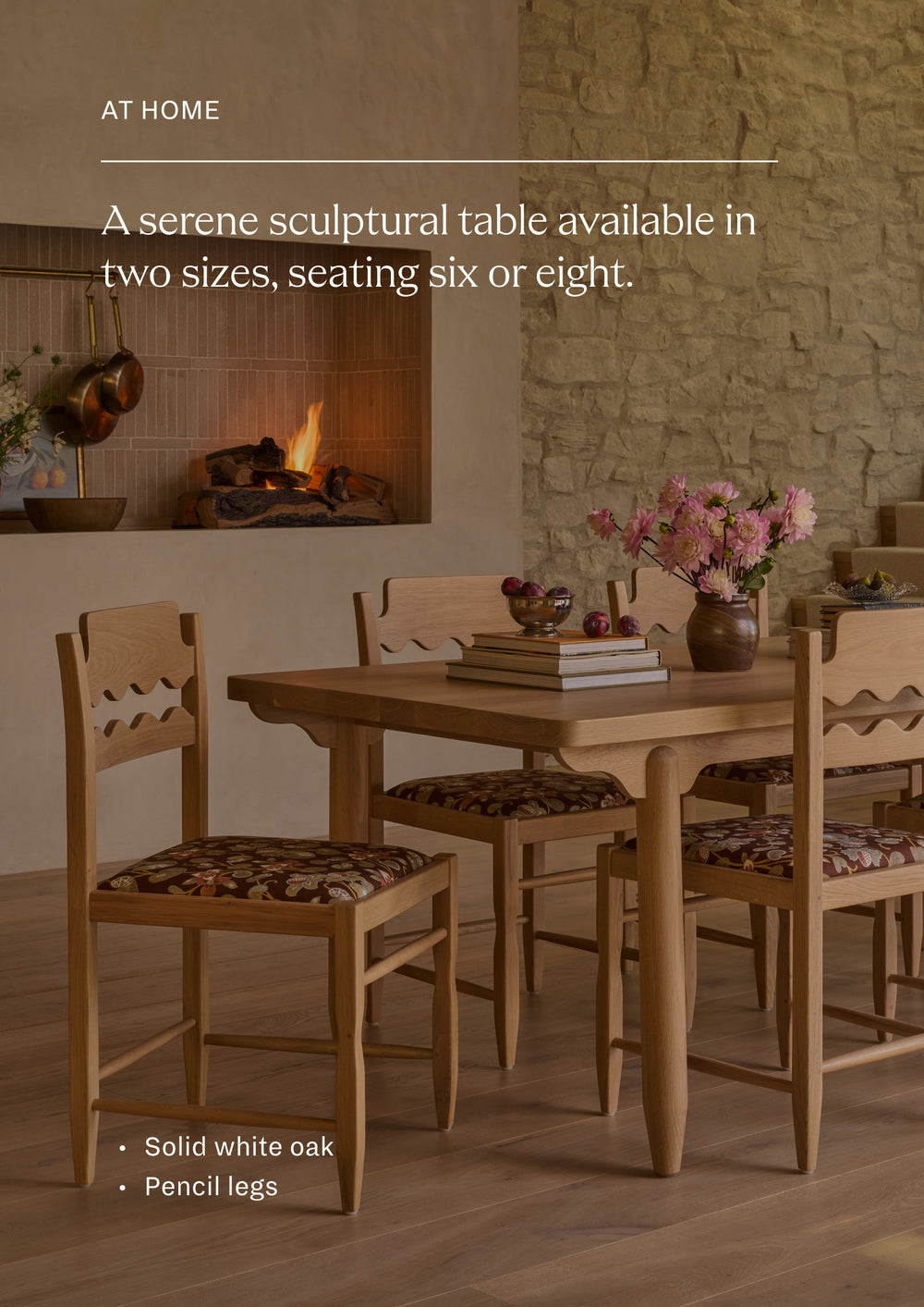 Available in two sizes - seating six or eight. The dining table styled with coordinating dining chairs in a warm, inviting dining room. Surrounded by floral-upholstered seating and set against a stone fireplace, the table creates a welcoming space for gathering and entertaining.