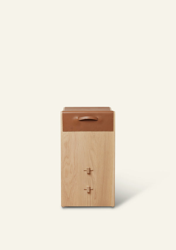 A side view of a white oak counter stool with waterfall cognac leather wrapped on the seat. 