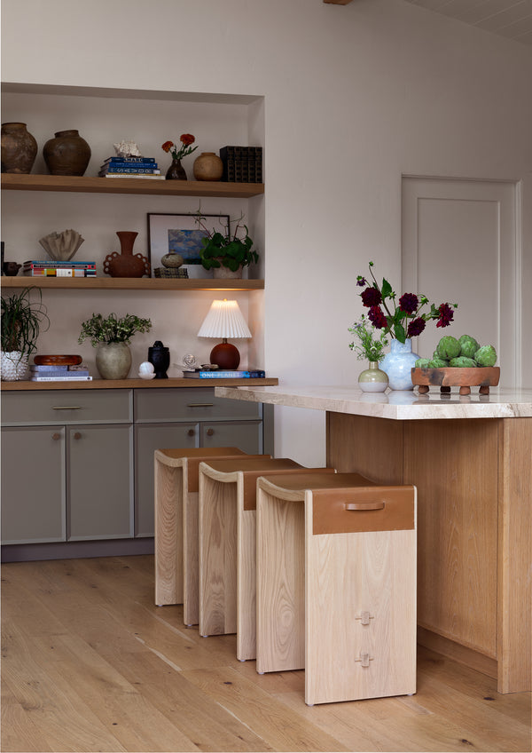 Aya backless counter stool at a kitchen counter with a neutral color scheme.