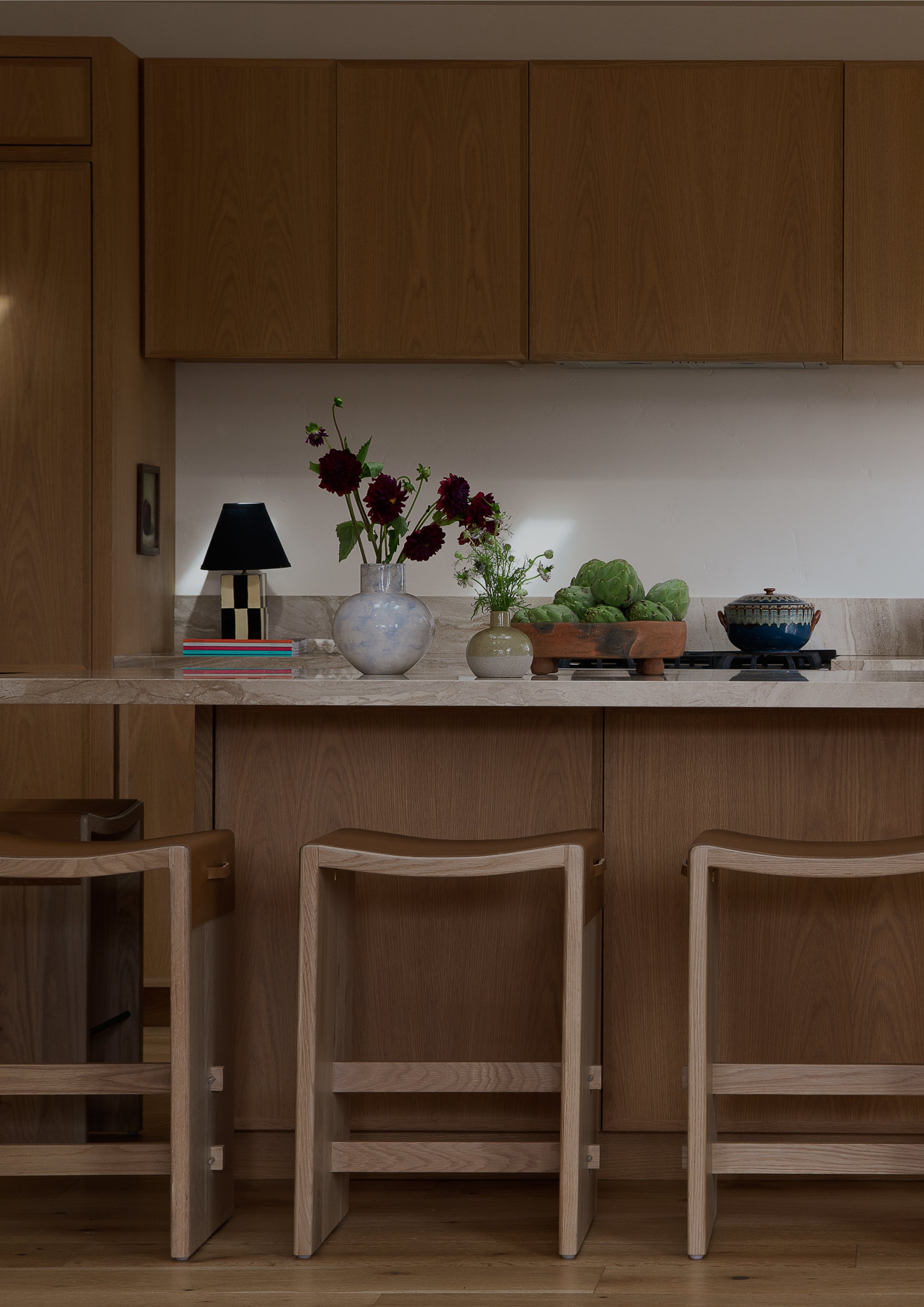 Aya backless counter stool in a modern, warm kitchen with florals and decor. 