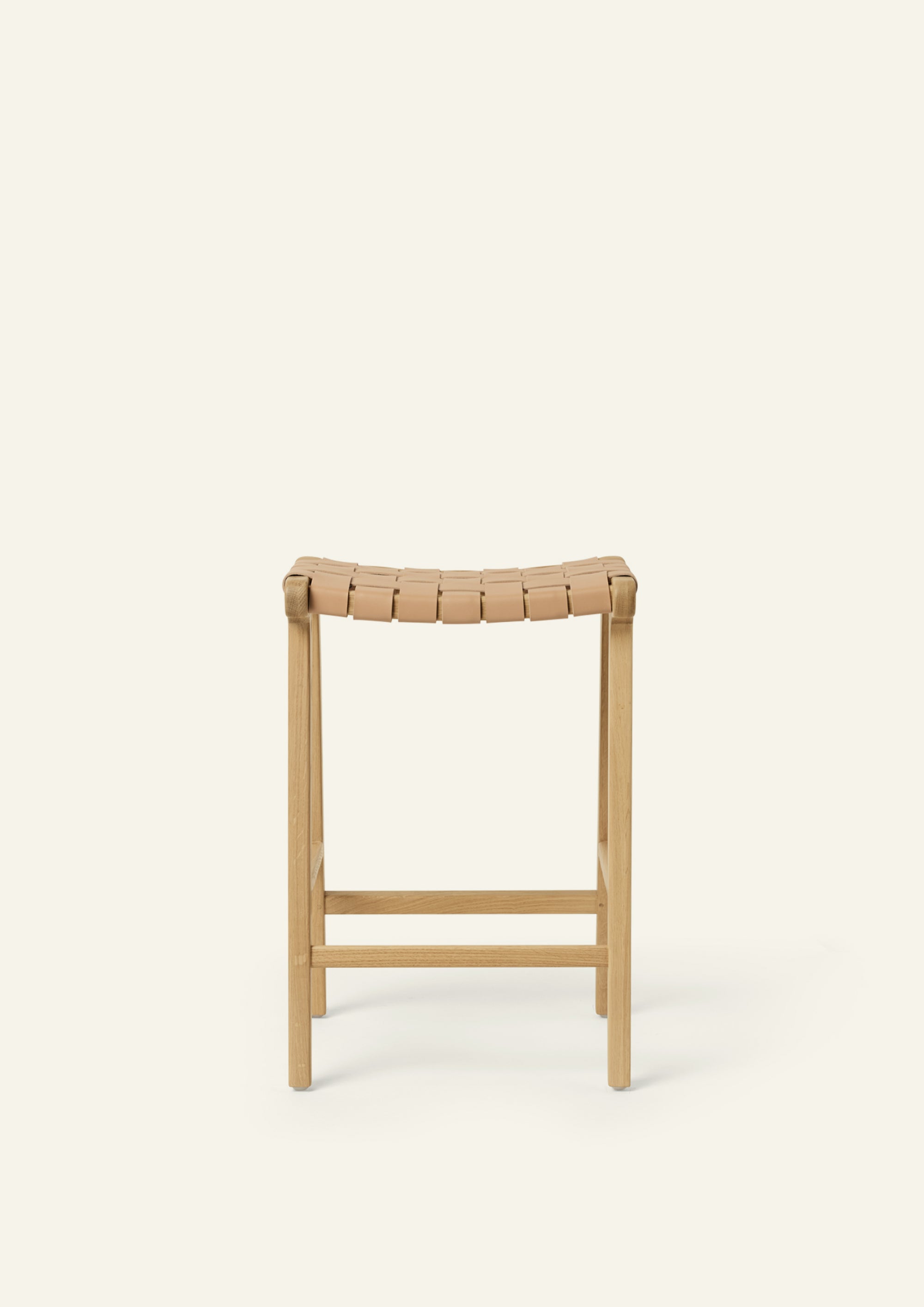 Front or back view of the Bali Counter Stool in solid white oak with a handwoven leather seat. The sculptural form and woven detailing create a timeless design suited for a variety of interiors.