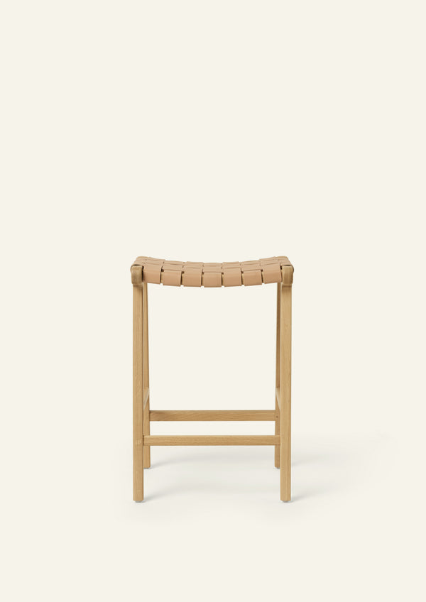 Front or back view of the Bali Counter Stool in solid white oak with a handwoven leather seat. The sculptural form and woven detailing create a timeless design suited for a variety of interiors.