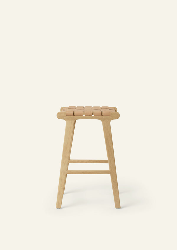 Side view of the Bali Counter Stool in solid white oak with a handwoven leather seat. The sculptural form and woven detailing create a timeless design suited for a variety of interiors.