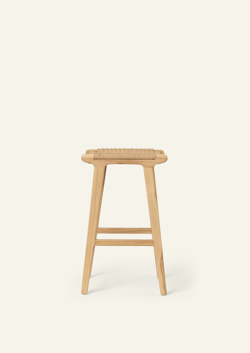 Side profile of the Bali Counter Stool crafted from solid teak with a handwoven natural paper cord seat. The gently tapered legs and clean silhouette create a light, sculptural presence.