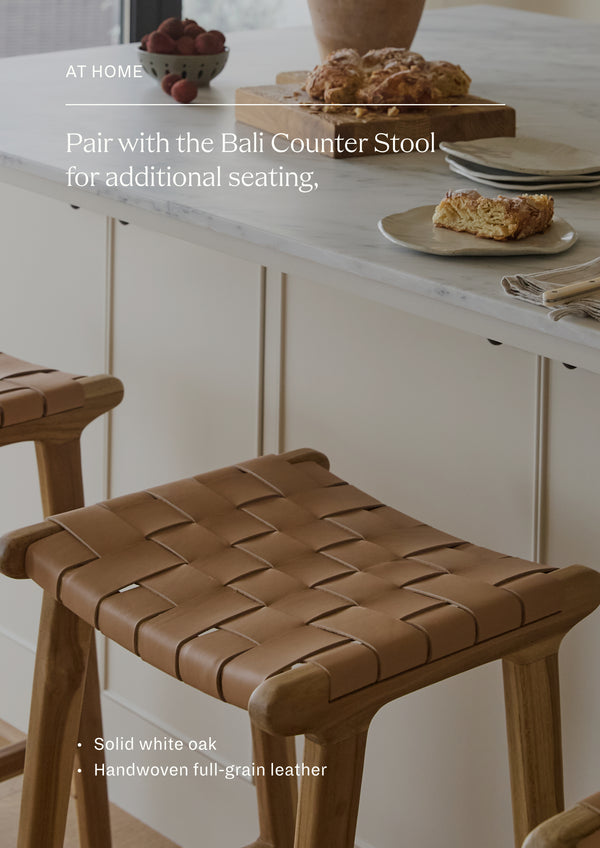 Pair with the Bali Counter Stool for additional seating. A collection of Bali Counter Stools arranged around a kitchen island, demonstrating their versatility for gathering spaces. The woven leather seats provide comfort, texture, and visual warmth.