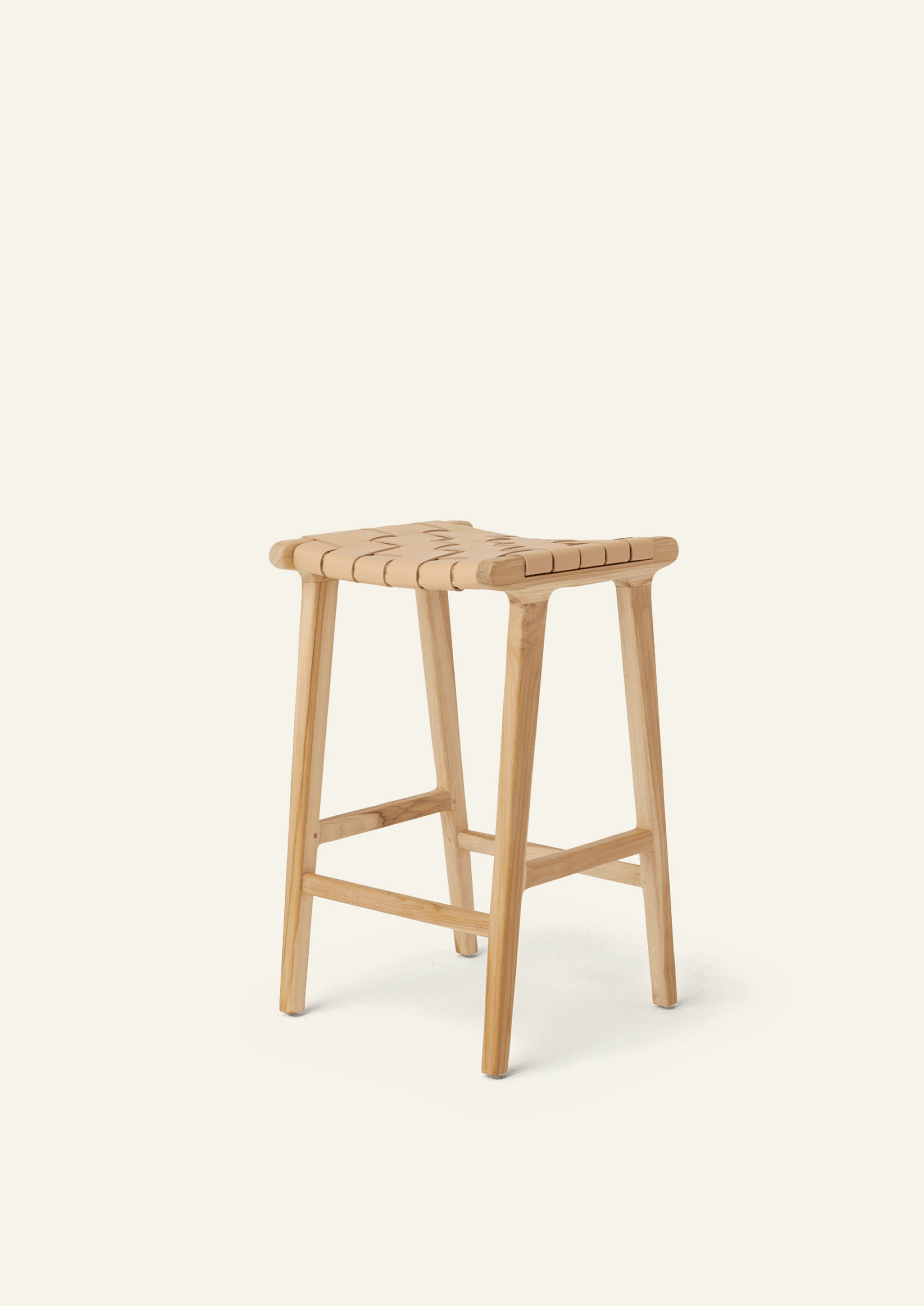 Angled view of the Bali Counter Stool in solid white oak with a handwoven leather seat. The sculptural form and woven detailing create a timeless design suited for a variety of interiors.