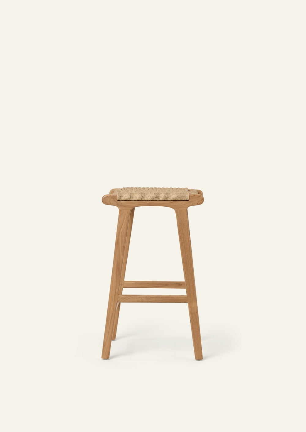 Side profile of the Bali Counter Stool crafted from solid teak and handwoven synthetic paper cord. The sculptural silhouette and gently tapered legs create a light, airy presence suited for both indoor and outdoor spaces.
