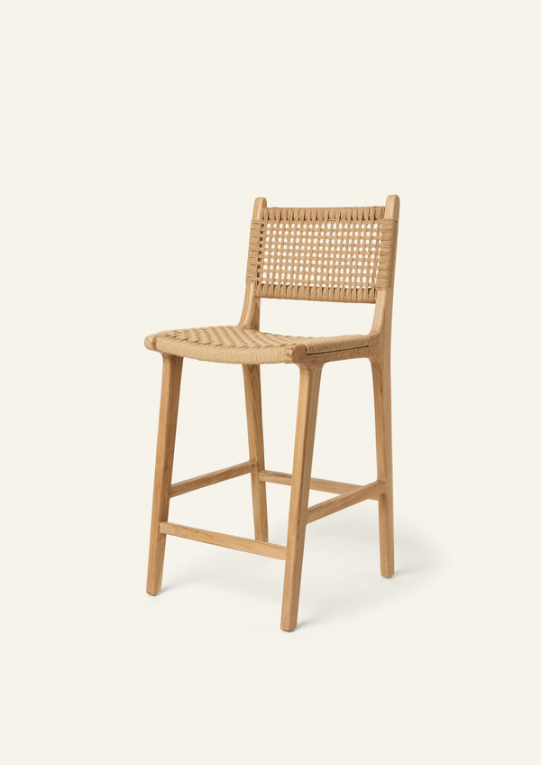 Bali counter stool crafted from solid teak with a handwoven paper cord seat and back, shown in a three-quarter view.
