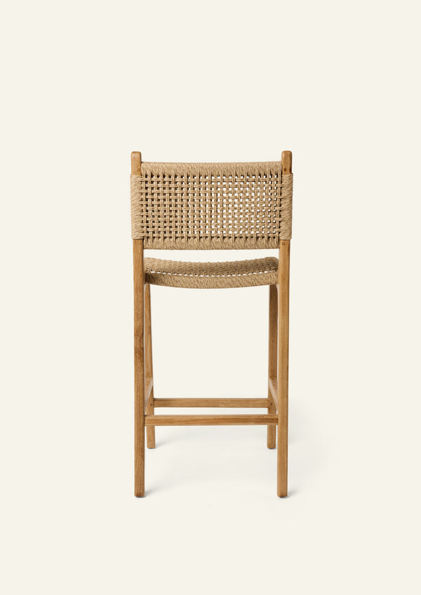 Back view of the Bali Counter Stool crafted from solid high-grade teak with a handwoven synthetic paper cord seat and back. The gently curved frame and woven texture create a relaxed silhouette suited for indoor and outdoor dining.