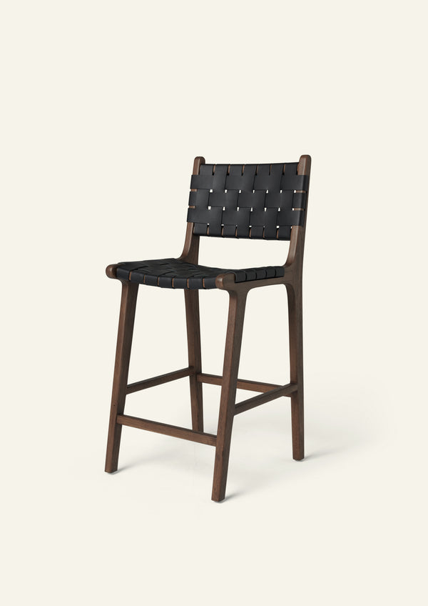 Bali Counter Stool in solid brown oak with handwoven black leather, shown in a three-quarter view.
