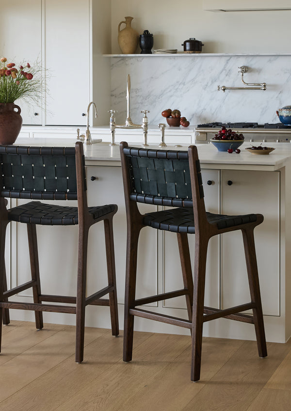Bali Counter Stools in black leather paired with a bright kitchen island, adding contrast, texture, and warmth to the space.