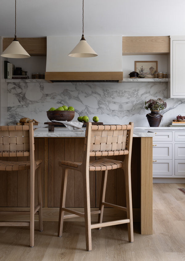 Bali Counter Stools in natural leather arranged at a white marble kitchen island, bringing warmth, texture, and casual sophistication to the space.