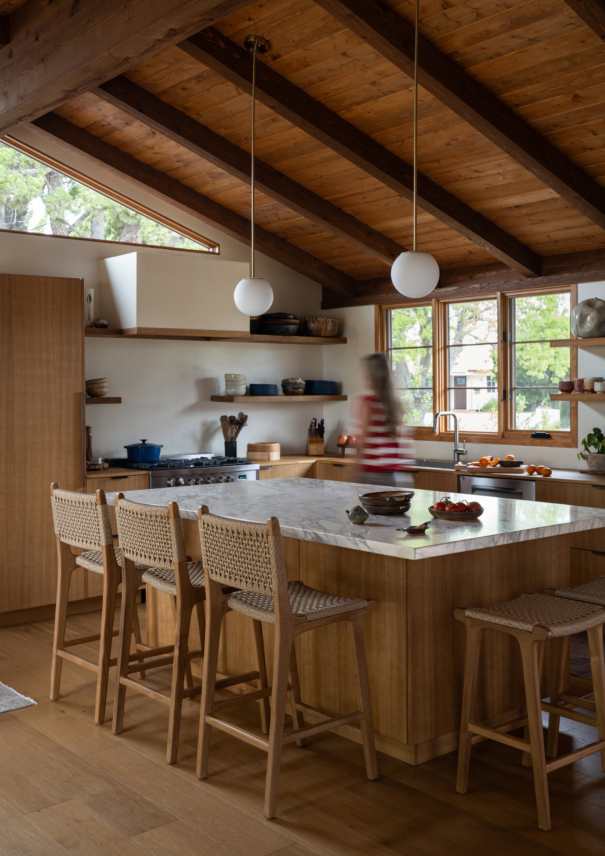 Bali Counter Stools in outdoor synthetic paper cord gathered around a kitchen island in a warm, natural home. Paired with the Bali Backless Counter Stool in outdoor synthetic to wrap around the kitchen island.