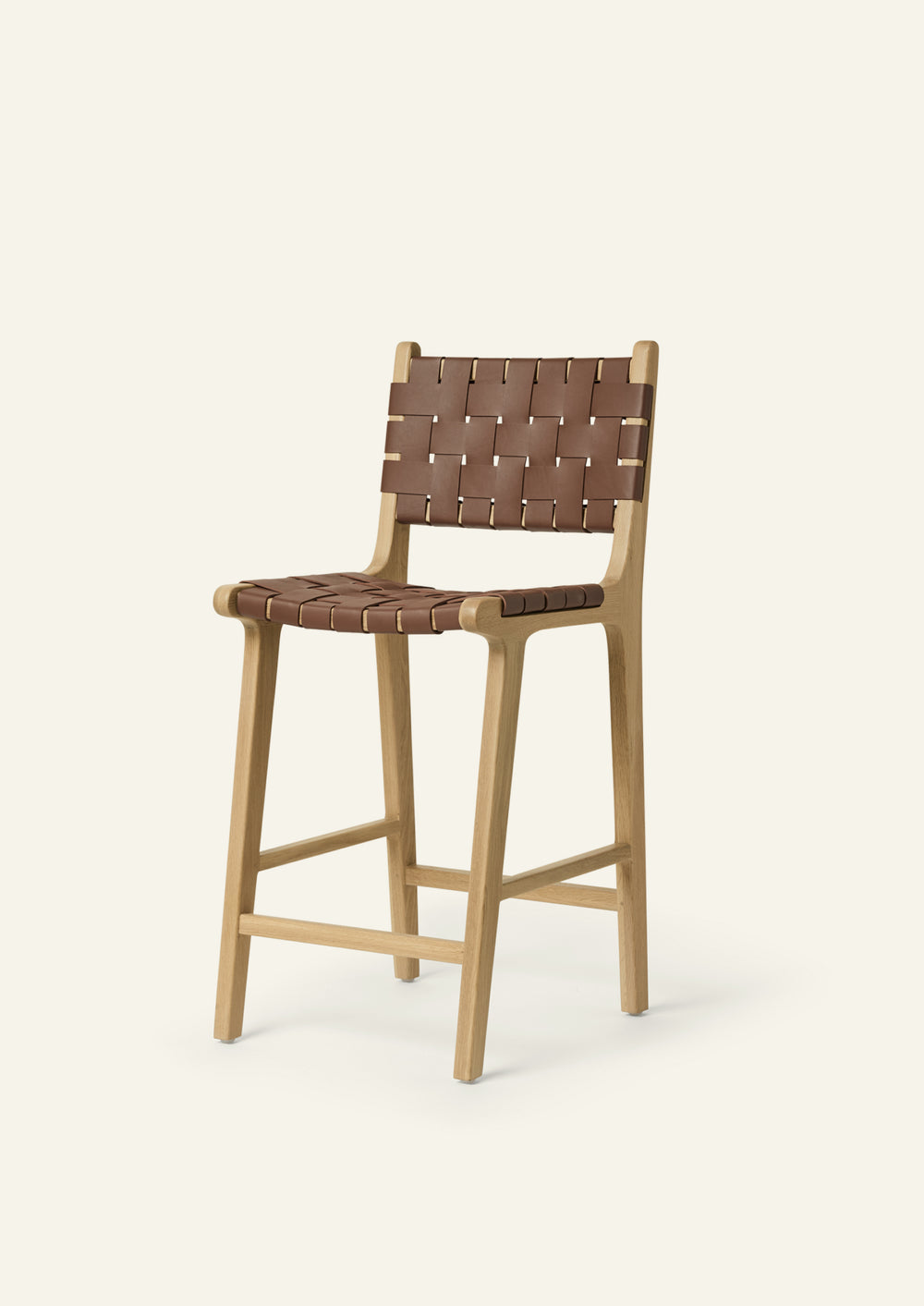 Bali Counter Stool in solid white oak with handwoven whiskey leather, shown in a three-quarter view.