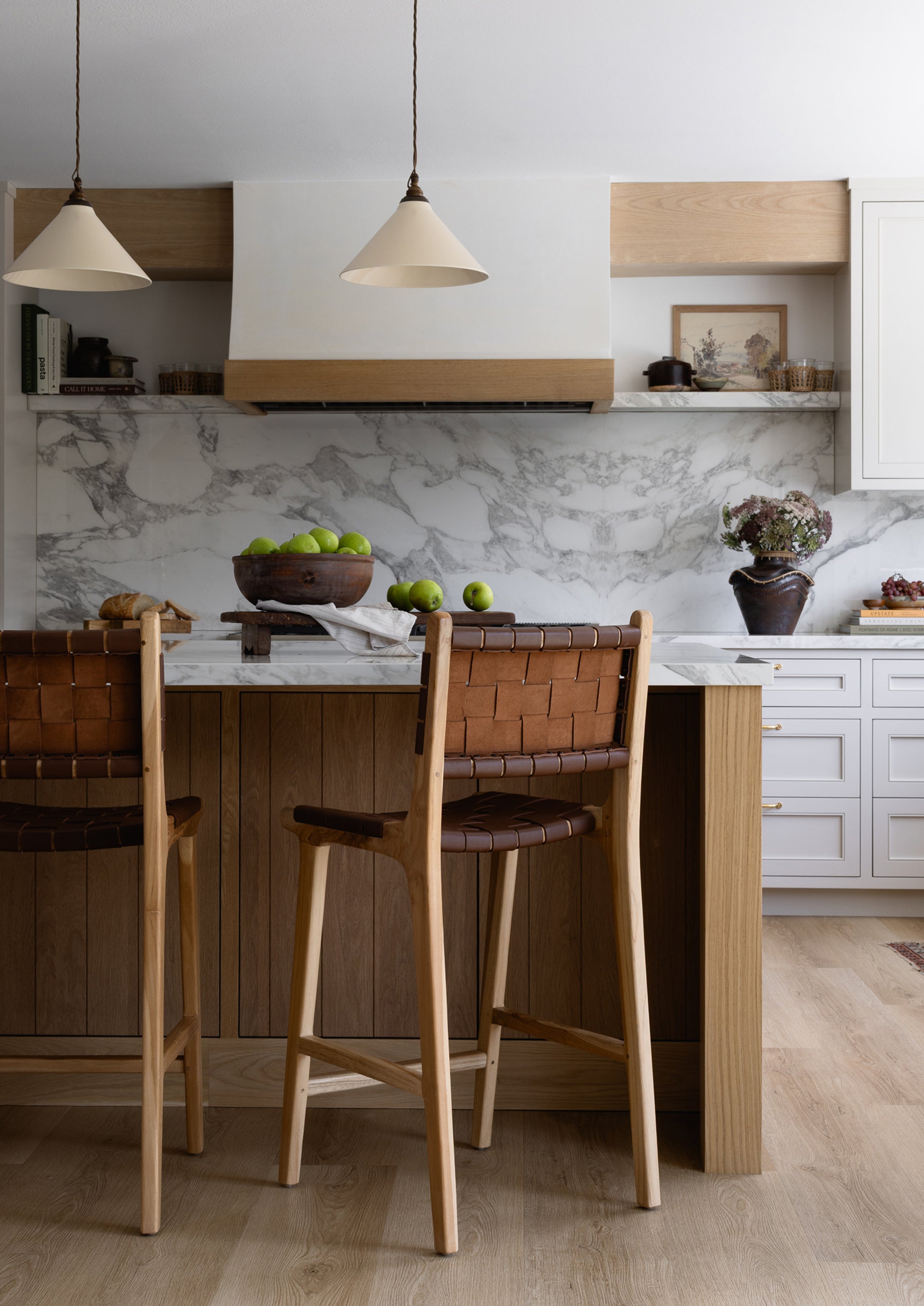 Bali Counter Stools in whiskey leather paired with a marble-topped kitchen island, adding warmth, texture, and timeless character to the space.