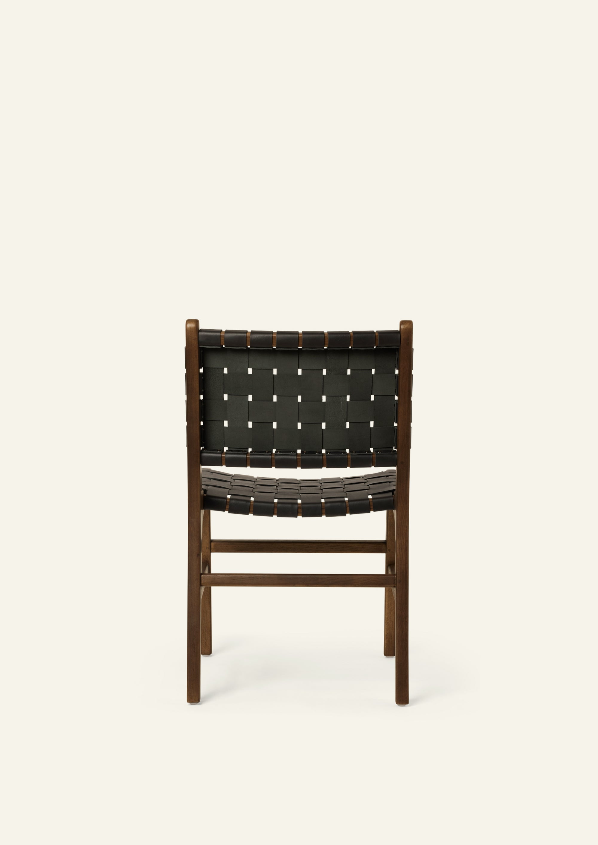 Rear view of the Bali Dining Chair showcasing the handwoven black leather back panel and solid brown oak construction. The woven pattern highlights the chair’s craftsmanship and architectural form.