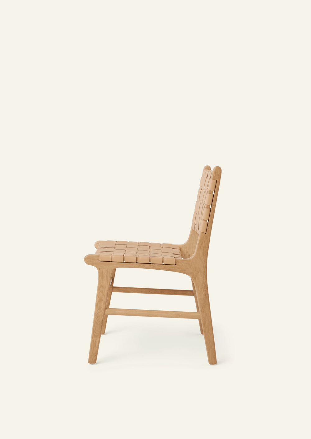 Side view of the Bali Dining Chair in white oak with woven full-grain natural leather. Rounded edges, tapered legs, and warm natural materials create a refined yet approachable dining chair.