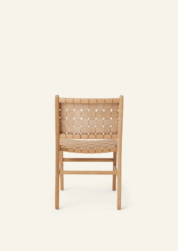 Back view of the Bali Dining Chair in white oak with woven full-grain natural leather. Rounded edges, tapered legs, and warm natural materials create a refined yet approachable dining chair.