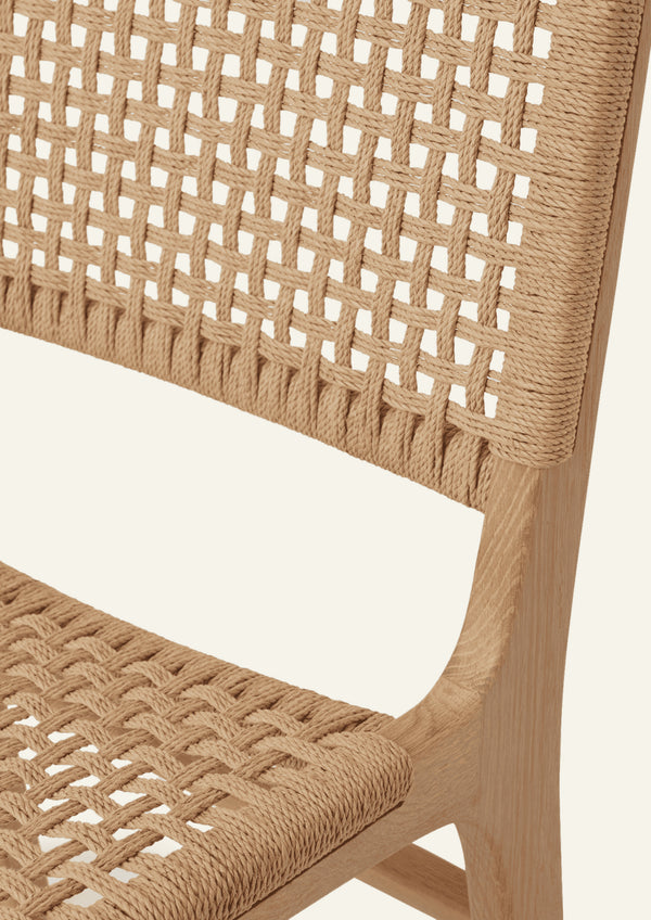 Close-up detail of the Bali Dining Chair's handwoven paper cord, showcasing the intricate basketweave pattern and natural texture.