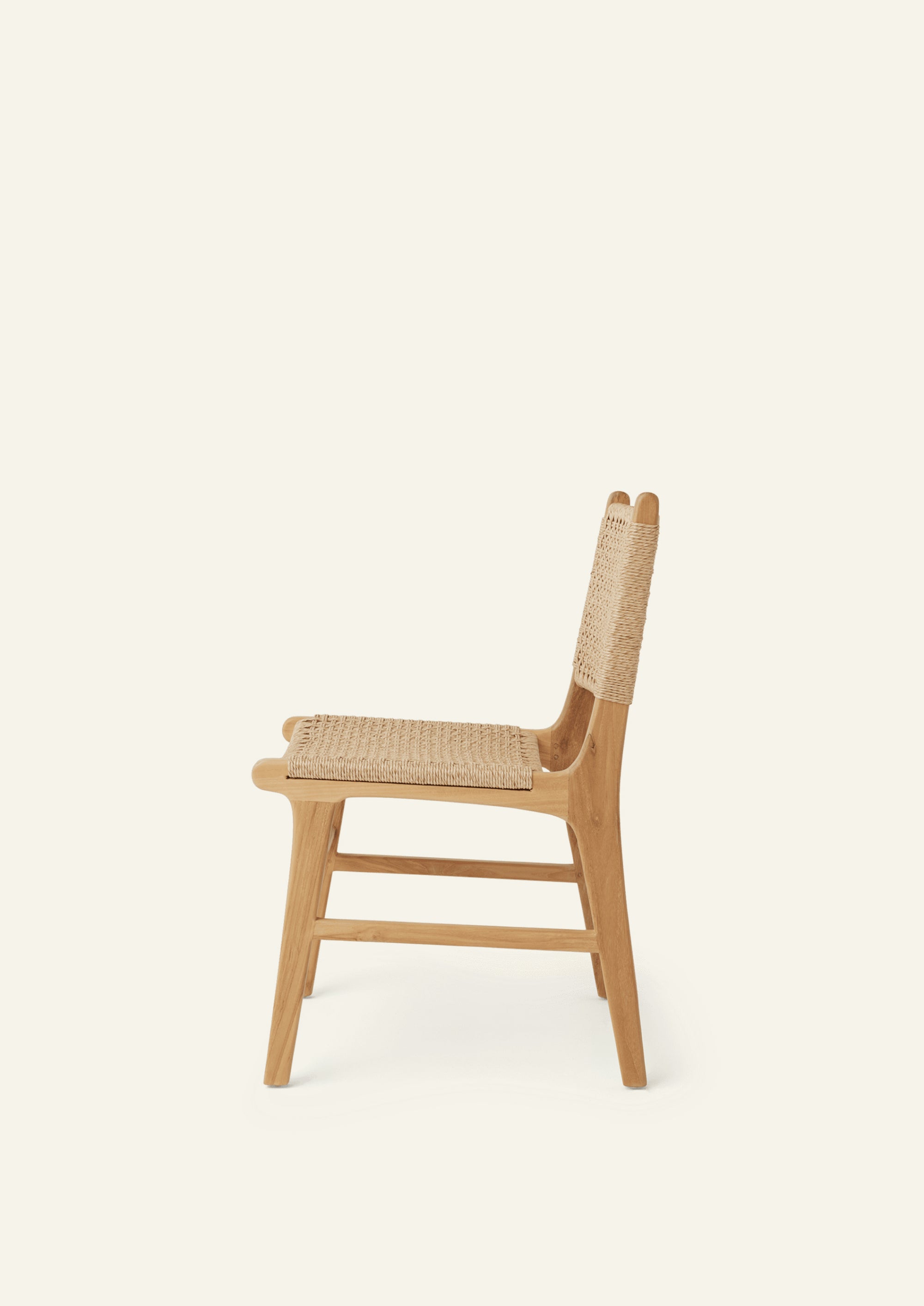 Side view of the Bali Dining Chair with a woven synthetic paper cord seat and back paired with a solid teak frame. The natural materials and clean lines create a timeless outdoor-inspired aesthetic.