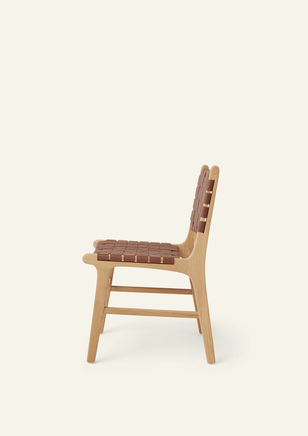 Side view of the Bali Dining Chair with a woven whiskey leather seat and back. Rounded edges, softly tapered legs, and natural materials create a warm and inviting presence.