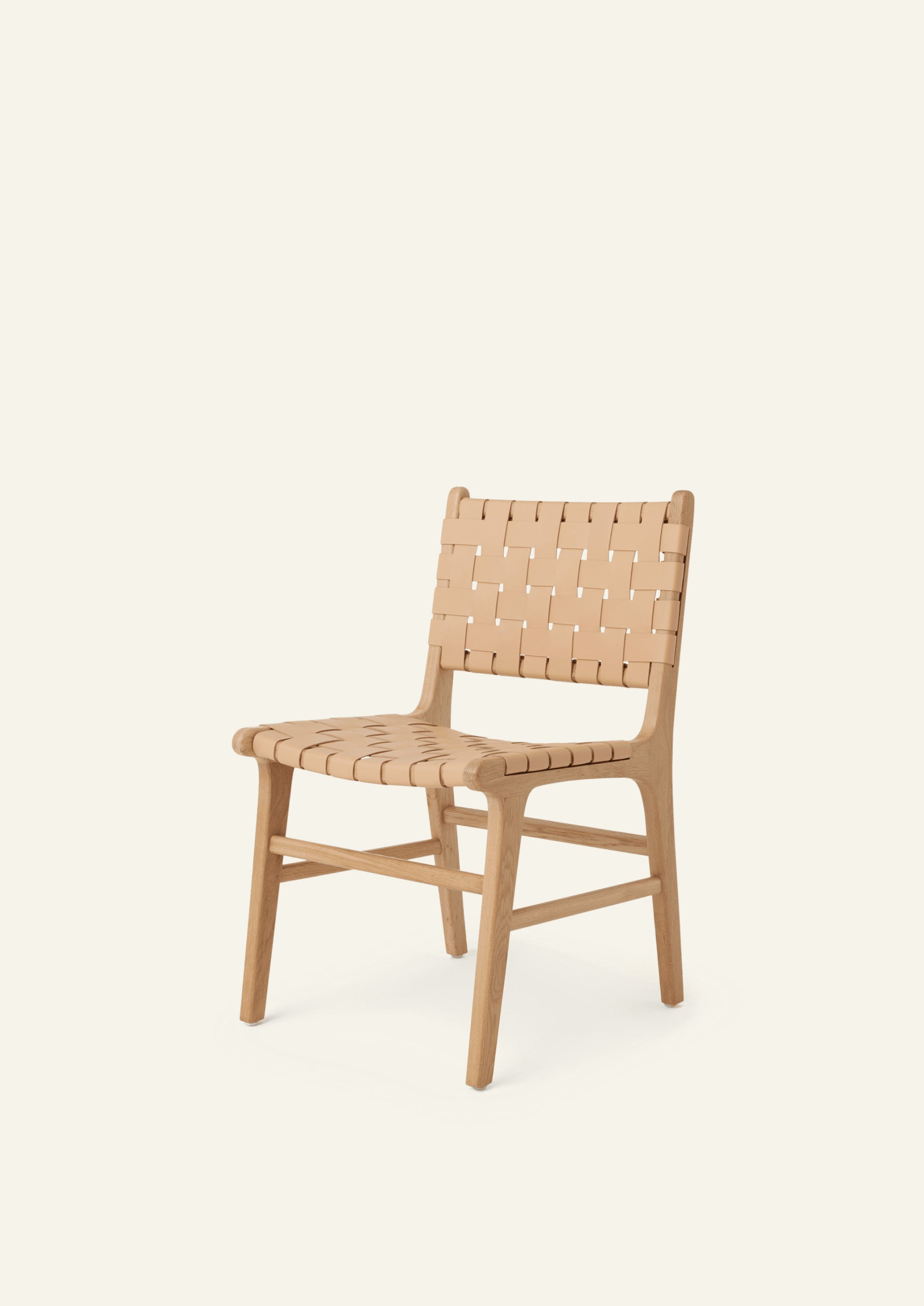 Angled view of the Bali Dining Chair in white oak with woven full-grain natural leather. Rounded edges, tapered legs, and warm natural materials create a refined yet approachable dining chair.