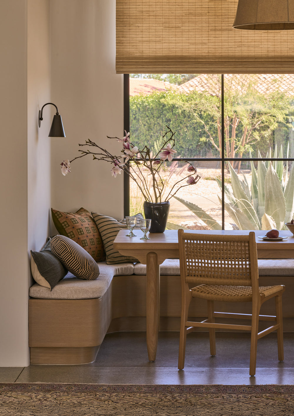 Bali Dining Chair in handwoven paper cord styled beside a built-in banquette and wood dining table in a sunlit breakfast nook.