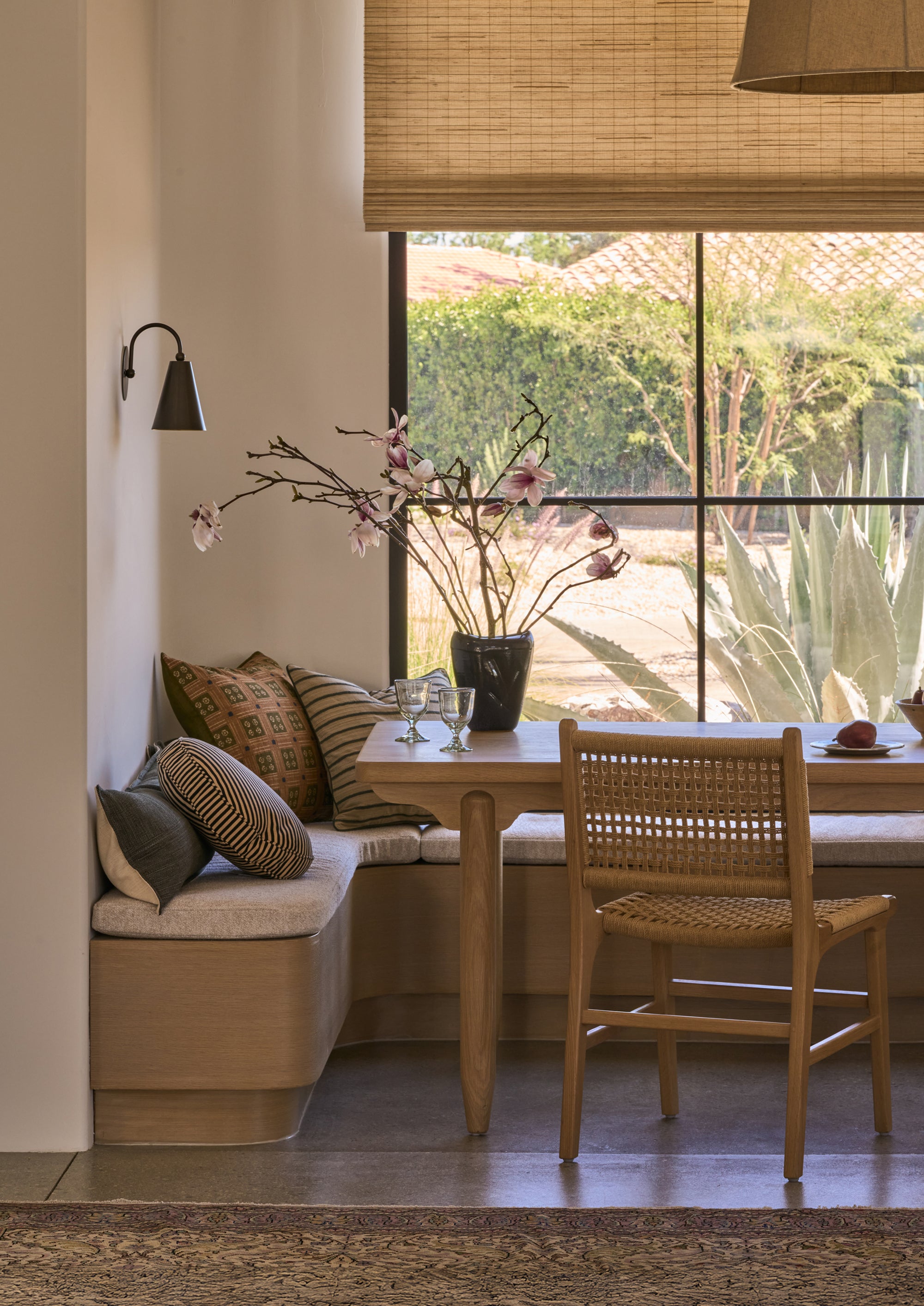 Bali Dining Chair in handwoven paper cord styled beside a built-in banquette and wood dining table in a sunlit breakfast nook.