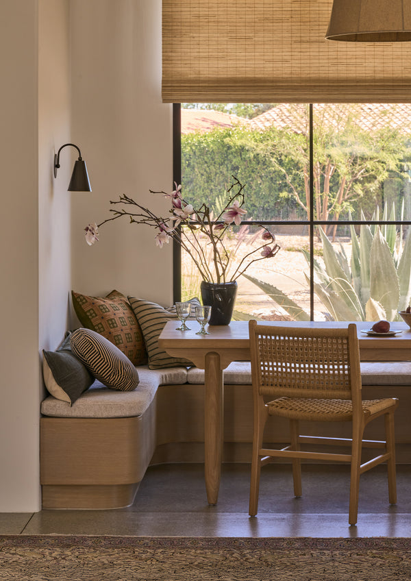 Bali Dining Chair in handwoven paper cord styled beside a built-in banquette and wood dining table in a sunlit breakfast nook.