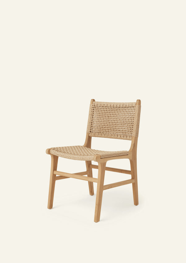 Angled view of the Bali Dining Chair with a woven synthetic paper cord seat and back paired with a solid teak frame. The natural materials and clean lines create a timeless outdoor-inspired aesthetic.