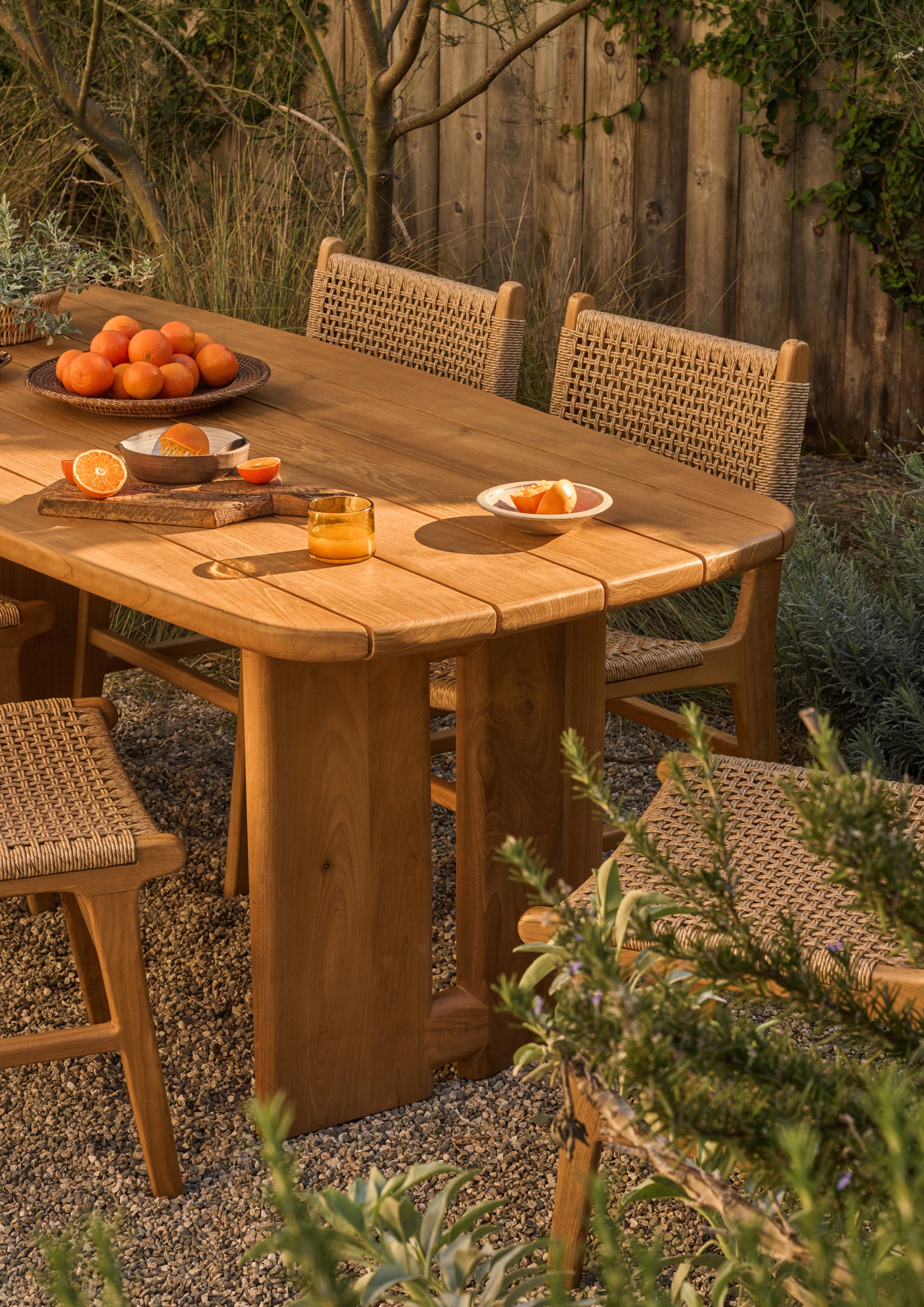 Bali Dining Chairs in outdoor synthetic paper cord arranged around the Hollis Dining Table, styled for outdoor dining and entertaining.