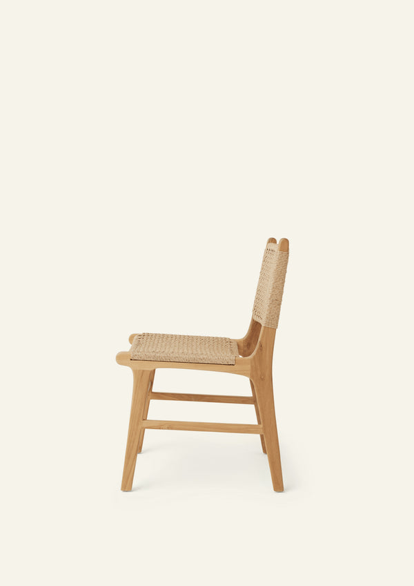 Profile view of the Bali Dining Chair highlighting the sculptural teak frame and woven outdoor synthetic paper cord seat and back.