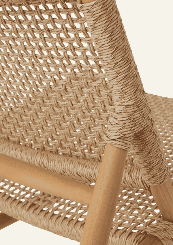 Detailed view of the lounge chair’s rear frame, showcasing tightly wrapped synthetic paper cord, warm teak grain, and structural joinery. The natural materials and open weave contribute to the chair’s light, airy appearance.
