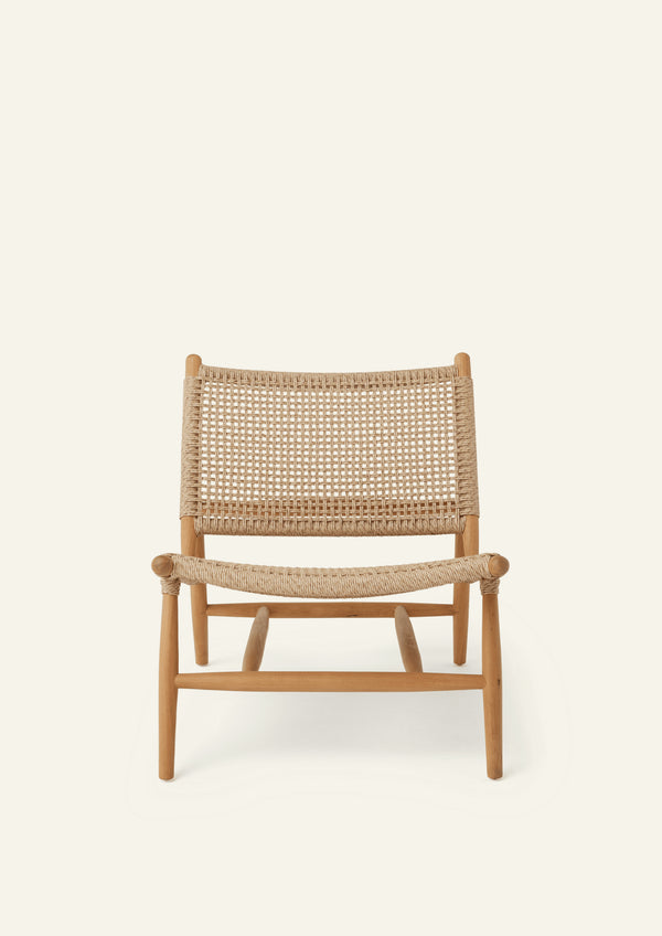 Front view of the lounge chair featuring a woven synthetic paper cord seat and backrest supported by a solid teak frame. The generous proportions and gently reclined profile offer casual comfort and timeless style.