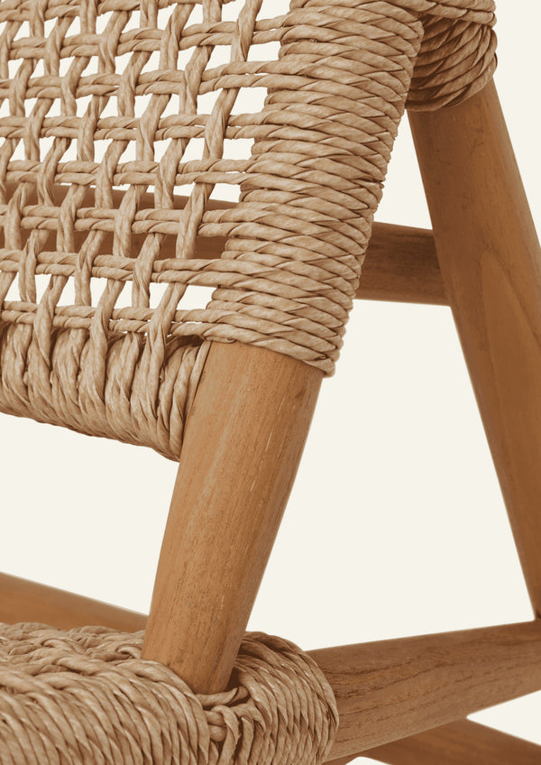 Close-up of the woven backrest showing the intricate open-weave pattern and synthetic paper cord wrapped around the teak frame. The handcrafted detailing highlights the chair’s texture, durability, and craftsmanship.