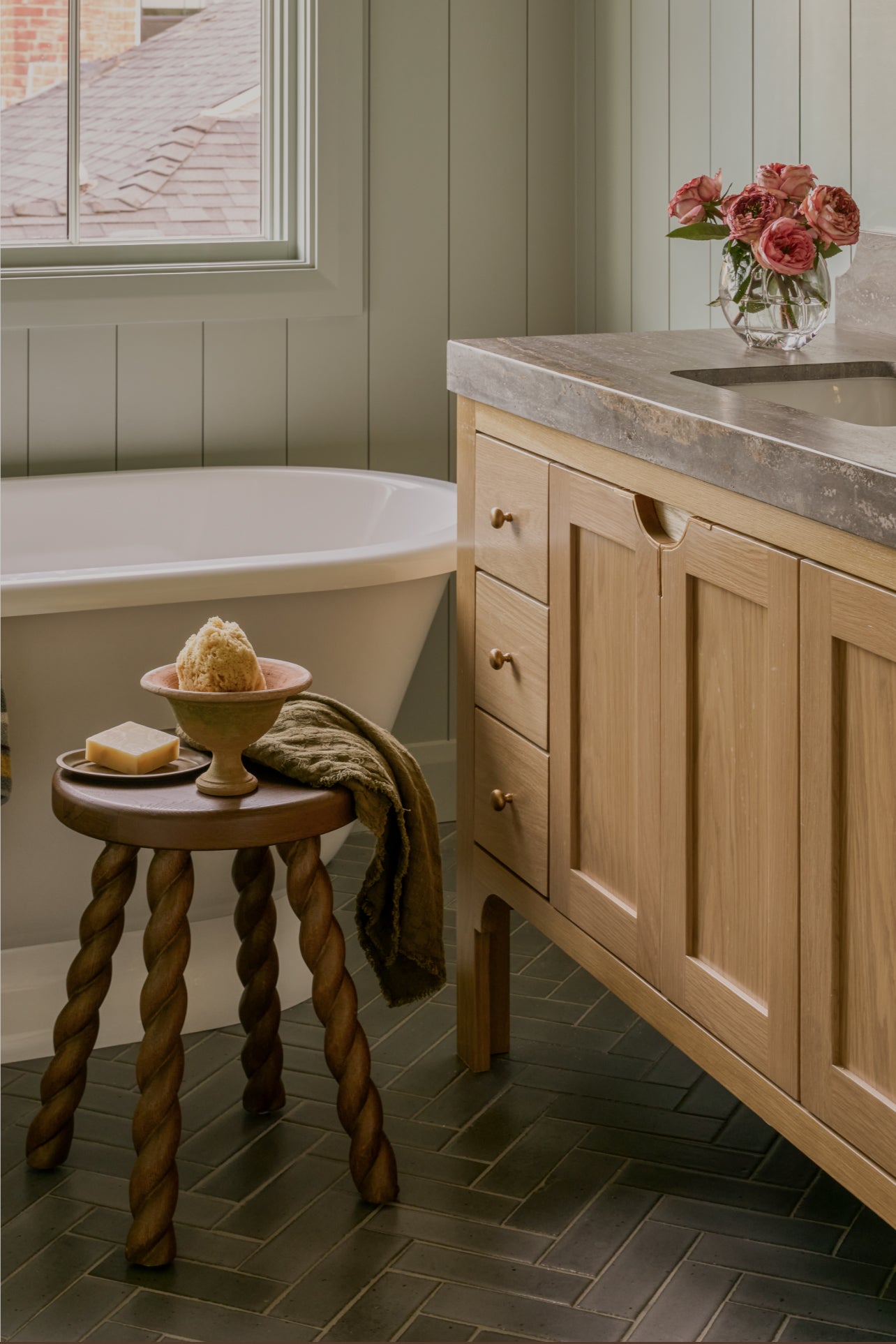 Bathroom with wooden vanity, bathtub, and decorative elements.