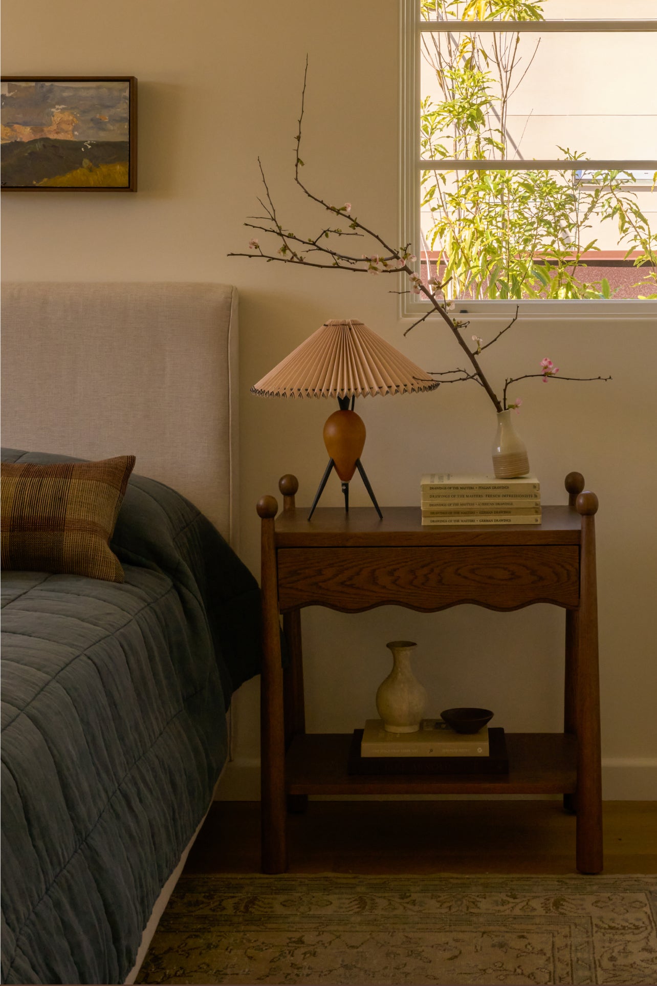 Bedroom with wooden nightstand, lamp, and decorative items.