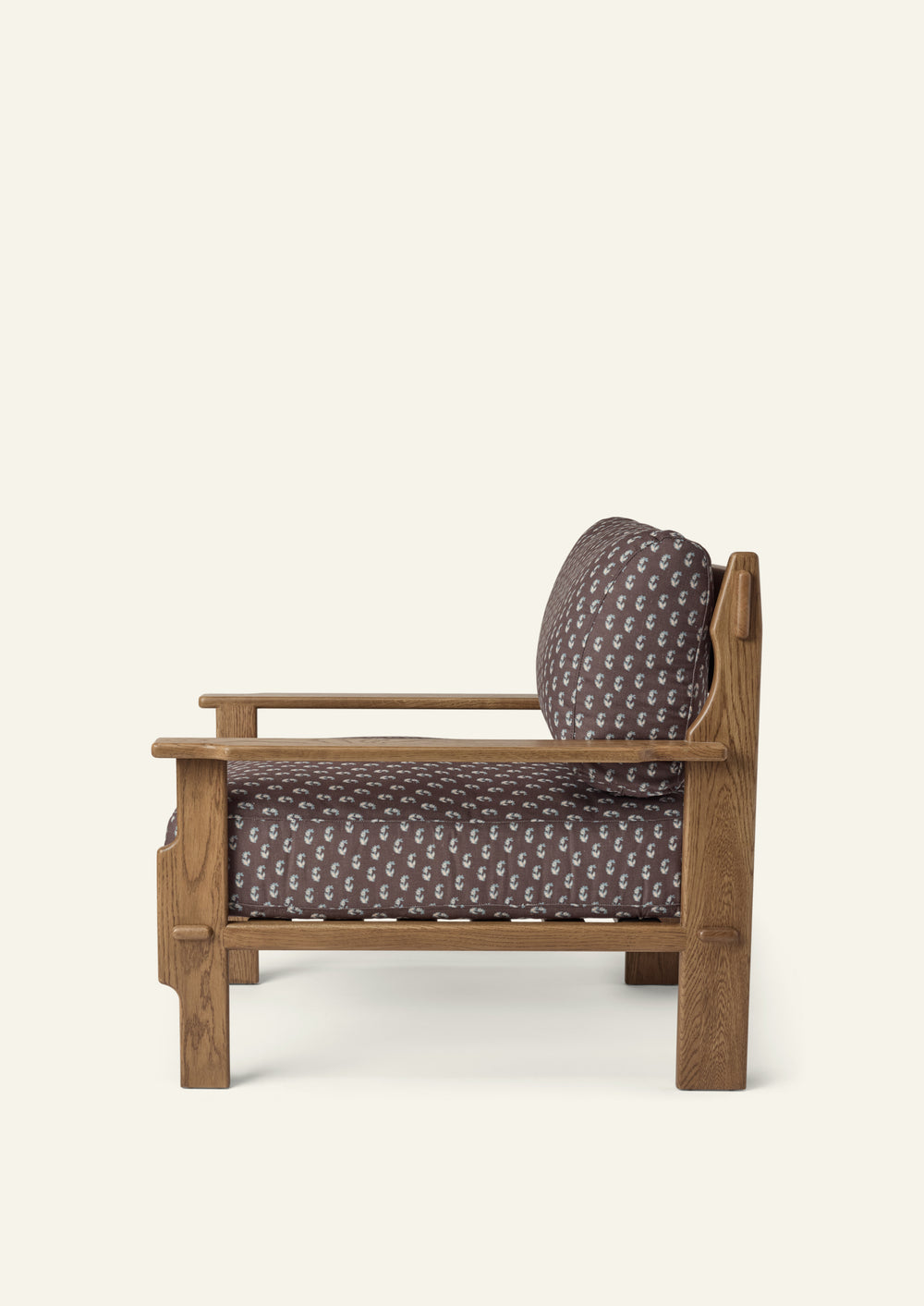 Side profile of the Cocoa Floral lounge chair highlighting its deep seat cushion, supportive back cushion, and solid honey oak frame. Clean lines and handcrafted details create a balance of comfort and craftsmanship.