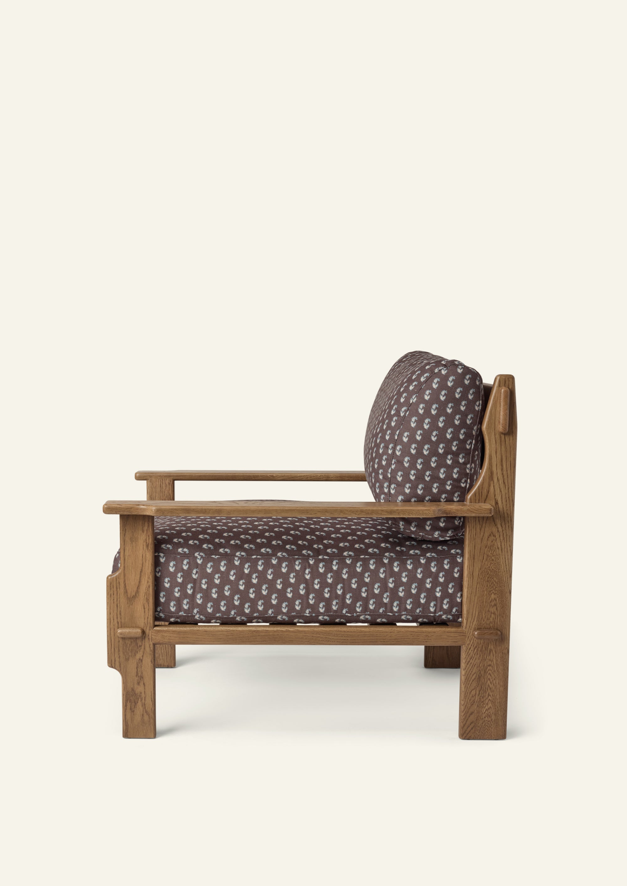 Side profile of the Cocoa Floral lounge chair highlighting its deep seat cushion, supportive back cushion, and solid honey oak frame. Clean lines and handcrafted details create a balance of comfort and craftsmanship.