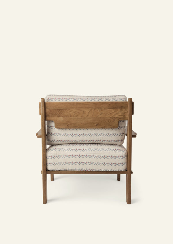 Rear view of the lounge chair showcasing the solid honey oak frame, exposed wood back panel, and Neutral Arches upholstered cushions. Thoughtful craftsmanship highlights the chair from every angle.