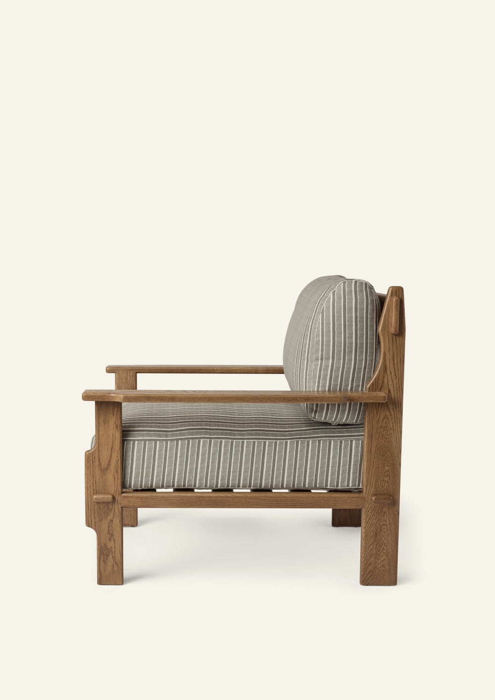 Side profile of the lounge chair highlighting its deep seat cushion, supportive back cushion, and solid honey oak frame. Clean lines and handcrafted details balance comfort with timeless design.