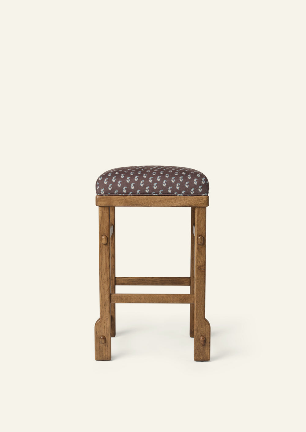 Side profile of the upholstered counter stool highlighting the Cocoa Floral cushion, solid honey oak frame, and exposed joinery details. The balanced proportions and handcrafted construction bring comfort and timeless appeal to kitchen and dining spaces.