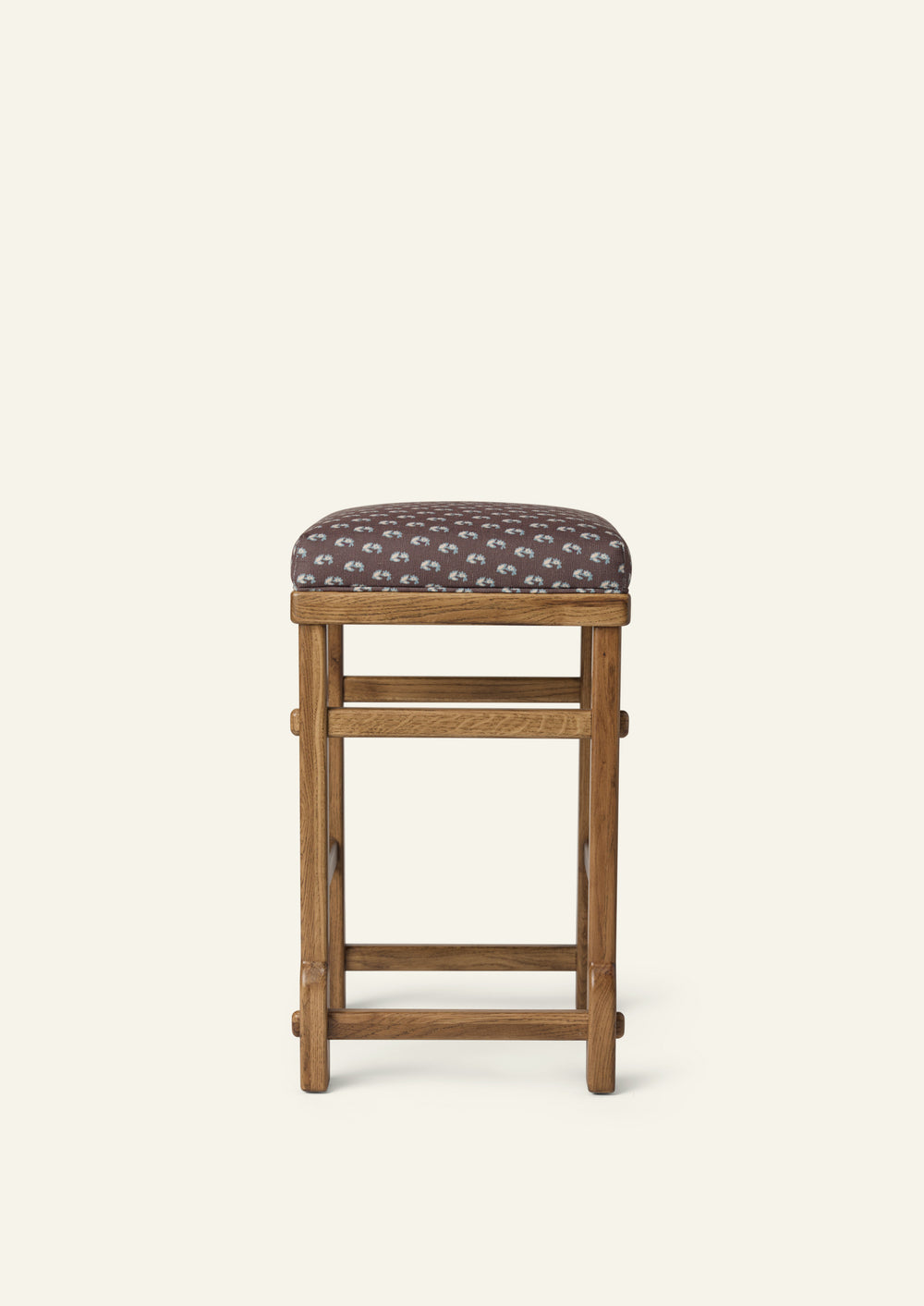ront view of an upholstered counter stool with Cocoa Floral fabric and a solid honey oak frame. Clean lines and handcrafted joinery create a timeless, versatile design.