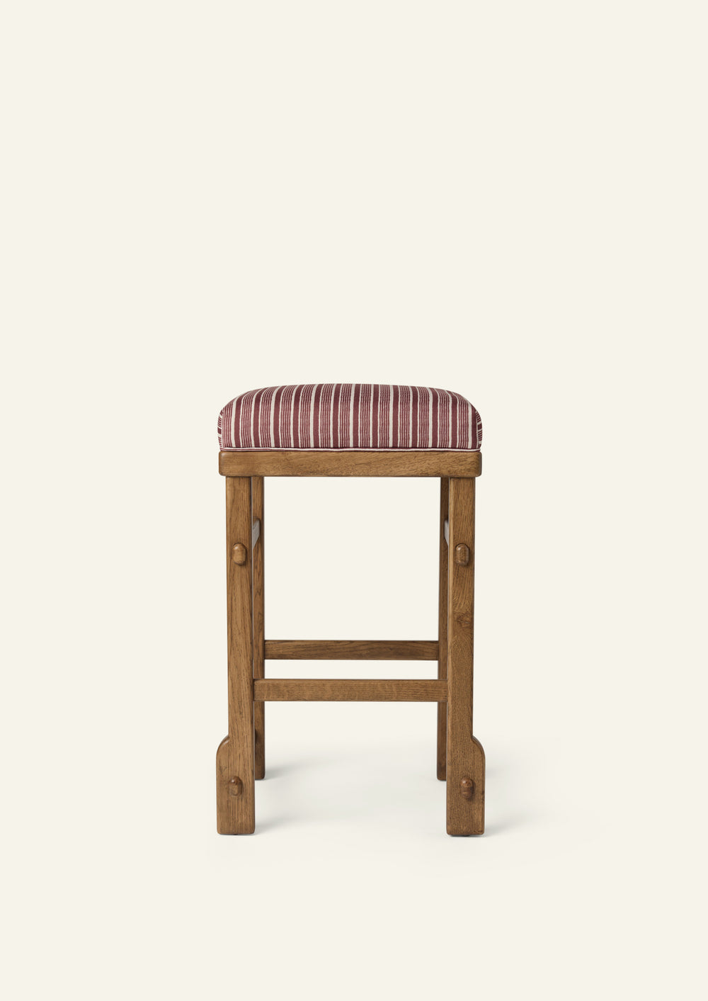 Front profile of the upholstered counter stool highlighting the striped cushion, solid honey oak frame, and exposed joinery details. The balanced proportions and timeless construction blend comfort with everyday functionality.