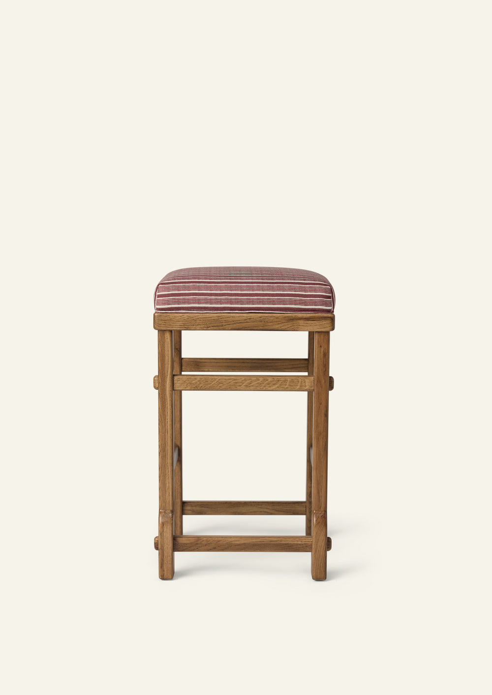 Side profile of the upholstered counter stool highlighting the striped cushion, solid honey oak frame, and exposed joinery details. The balanced proportions and timeless construction blend comfort with everyday functionality.