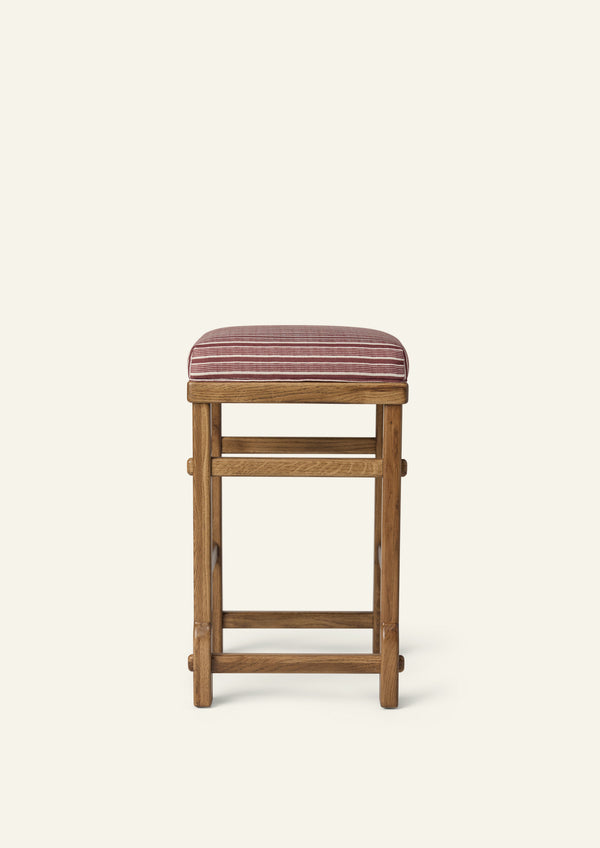 Side profile of the upholstered counter stool highlighting the striped cushion, solid honey oak frame, and exposed joinery details. The balanced proportions and timeless construction blend comfort with everyday functionality.