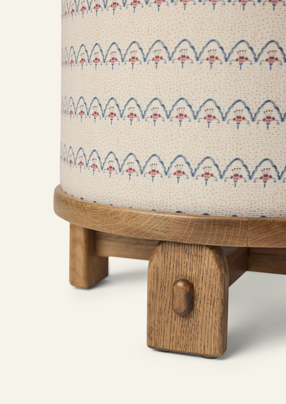 Close-up of the Yara Pouf showing the Neutral Arches fabric pattern and handcrafted honey oak base. The textured woven upholstery and rounded wood edge highlight the pouf’s artisanal details.